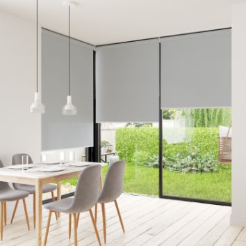 Three roller blinds fitted in kitchen setting displayed with grey fabric